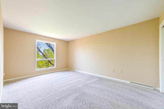 empty room with baseboards, baseboard heating, and carpet