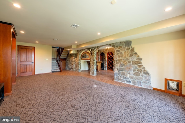 unfurnished living room featuring baseboards, carpet, stairs, and recessed lighting