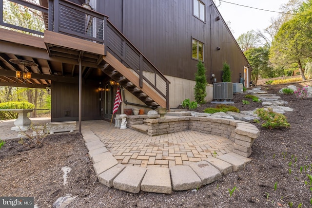 view of patio with central AC unit, a deck, and stairway