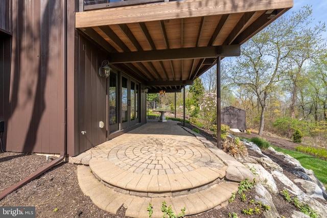 view of patio featuring french doors, an outdoor structure, and a storage unit