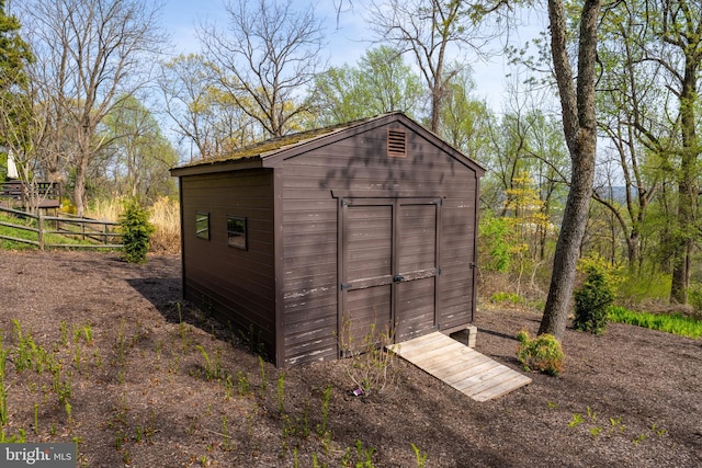 view of shed featuring fence