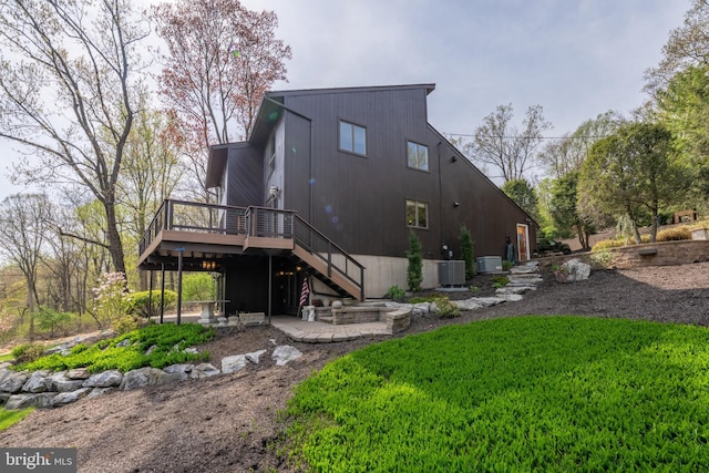 back of house with central AC unit, stairs, a deck, and a patio