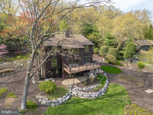 rear view of property with fence, a patio, a chimney, and a deck