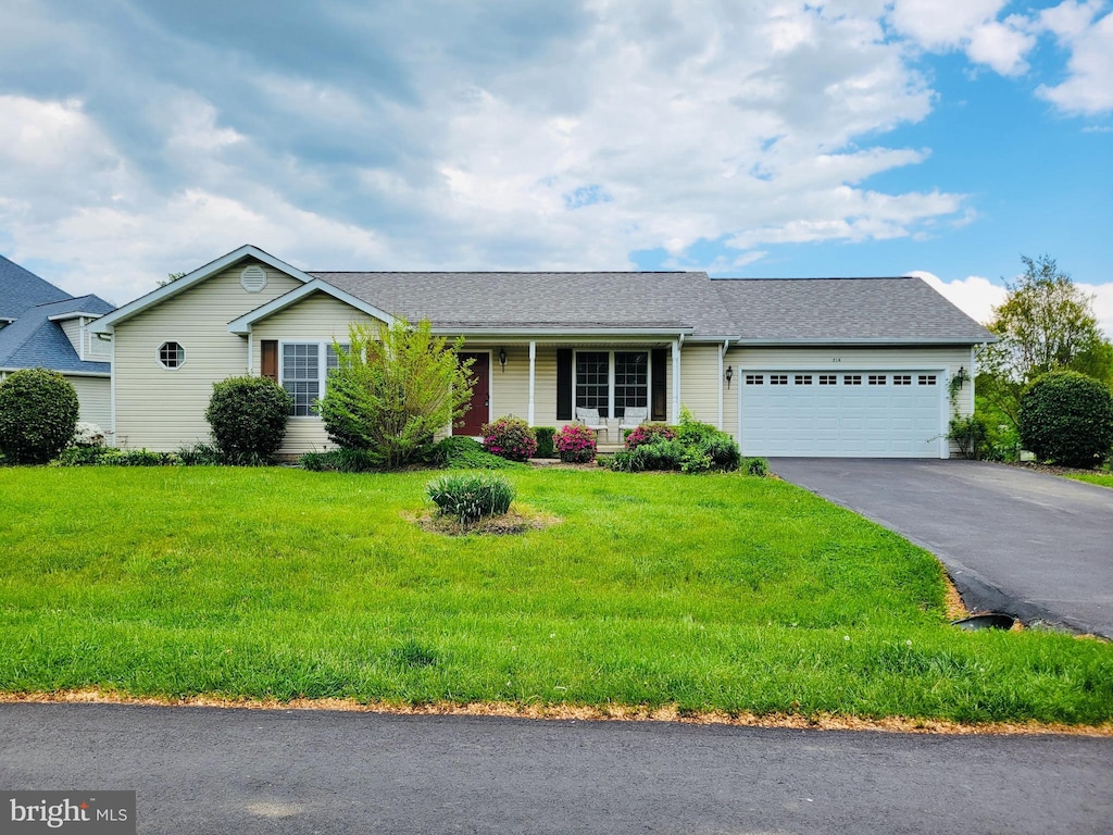 ranch-style home with driveway, a front lawn, roof with shingles, and a garage
