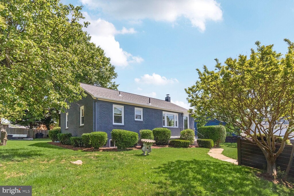 3319 King St, Alexandria, VA 22302 - back of property featuring a lawn, brick siding, fence, and a chimney