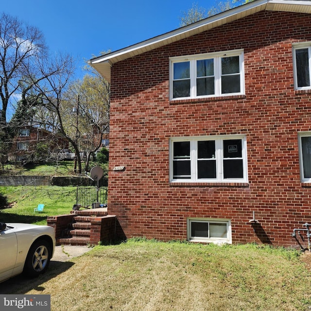 view of home's exterior featuring a yard and brick siding
