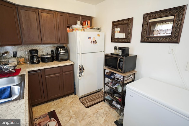 435 N St, Milford, DE 19963 - kitchen featuring fridge, dark brown cabinets, light countertops, a sink, and freestanding refrigerator
