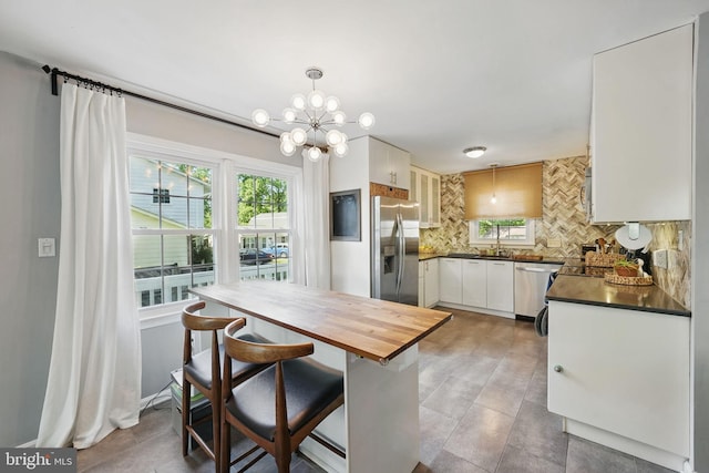 13003 Standish Ct, Woodbridge, VA 22192 - kitchen featuring stainless steel appliances, healthy amount of natural light, tasteful backsplash, and butcher block counters