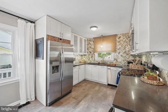 13003 Standish Ct, Woodbridge, VA 22192 - kitchen with appliances with stainless steel finishes, dark countertops, decorative backsplash, and white cabinets