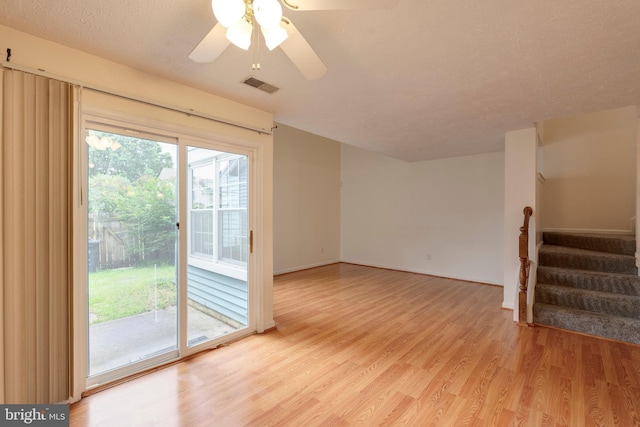 13830 Lord Fairfax Pl, Upper Marlboro, MD 20772 - unfurnished room with light wood-type flooring, stairs, ceiling fan, baseboards, and a textured ceiling