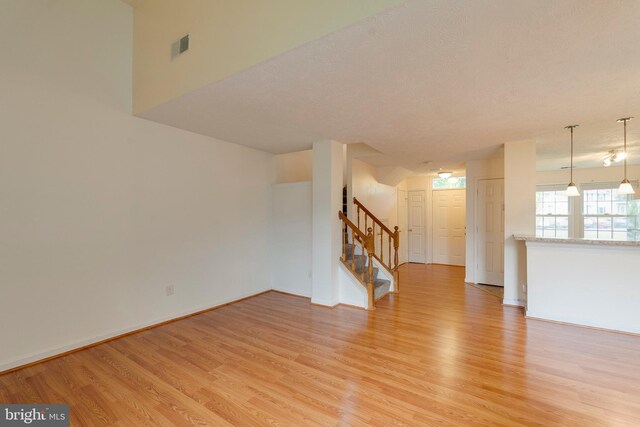 13830 Lord Fairfax Pl, Upper Marlboro, MD 20772 - unfurnished living room featuring light wood-style floors, stairs, and baseboards