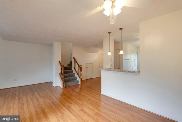 13830 Lord Fairfax Pl, Upper Marlboro, MD 20772 - unfurnished living room featuring light wood-type flooring, stairway, a ceiling fan, and baseboards