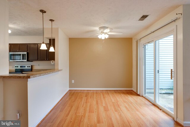 13830 Lord Fairfax Pl, Upper Marlboro, MD 20772 - kitchen featuring appliances with stainless steel finishes, a textured ceiling, light wood finished floors, ceiling fan, and pendant lighting