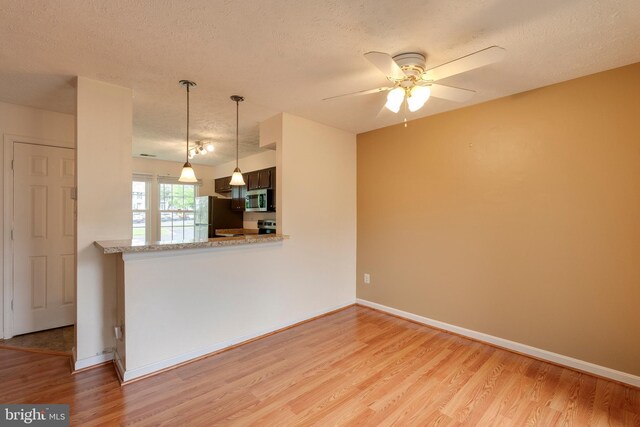 13830 Lord Fairfax Pl, Upper Marlboro, MD 20772 - unfurnished living room featuring a textured ceiling, light wood finished floors, a ceiling fan, and baseboards