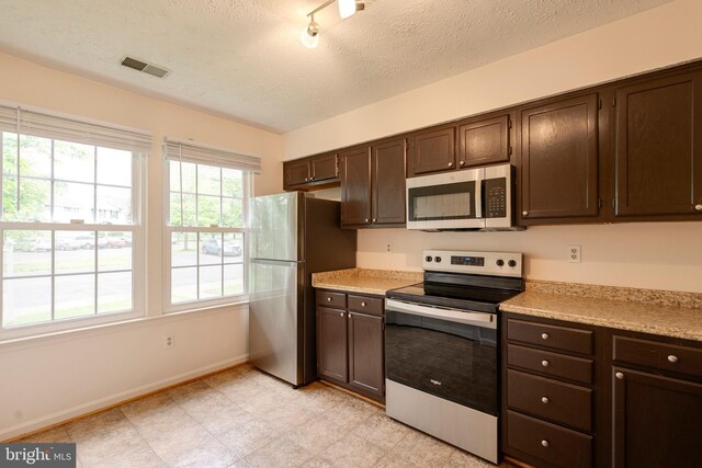 13830 Lord Fairfax Pl, Upper Marlboro, MD 20772 - kitchen featuring appliances with stainless steel finishes, dark brown cabinets, light countertops, baseboards, and a textured ceiling