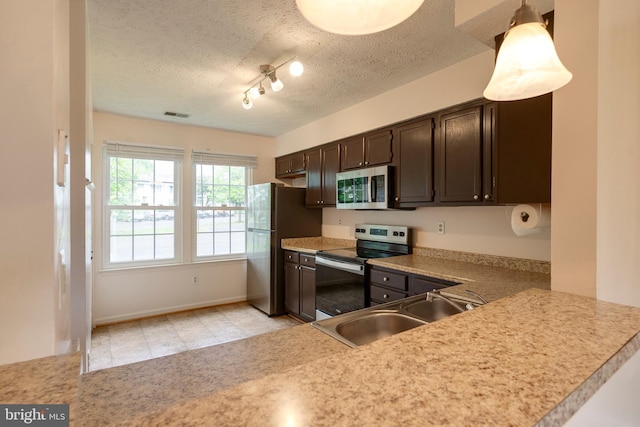 13830 Lord Fairfax Pl, Upper Marlboro, MD 20772 - kitchen with stainless steel appliances, a sink, dark brown cabinets, light countertops, and a textured ceiling