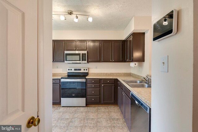 13830 Lord Fairfax Pl, Upper Marlboro, MD 20772 - kitchen with stainless steel appliances, a sink, dark brown cabinetry, a textured ceiling, and light countertops