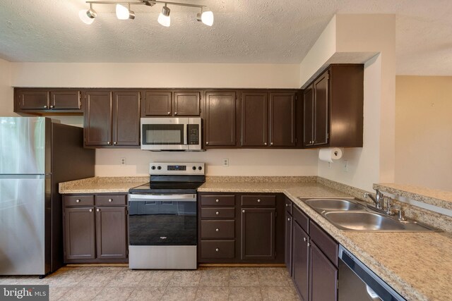 13830 Lord Fairfax Pl, Upper Marlboro, MD 20772 - kitchen featuring appliances with stainless steel finishes, a sink, dark brown cabinetry, and a textured ceiling