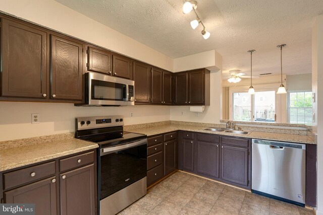 13830 Lord Fairfax Pl, Upper Marlboro, MD 20772 - kitchen featuring stainless steel appliances, a sink, dark brown cabinets, light countertops, and a textured ceiling