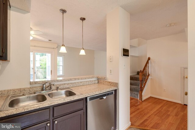 13830 Lord Fairfax Pl, Upper Marlboro, MD 20772 - kitchen with stainless steel dishwasher, a sink, light wood-style flooring, light countertops, and a textured ceiling