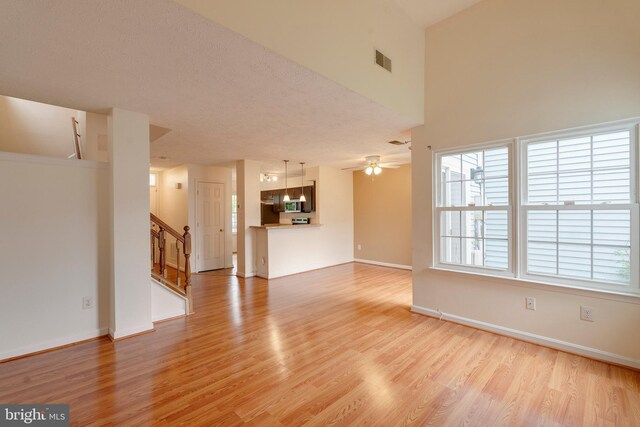 13830 Lord Fairfax Pl, Upper Marlboro, MD 20772 - unfurnished living room with light wood-type flooring, stairway, baseboards, and ceiling fan