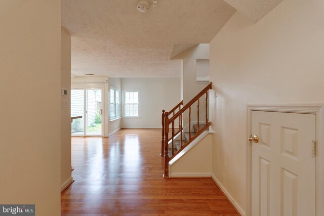 13830 Lord Fairfax Pl, Upper Marlboro, MD 20772 - hallway featuring a textured ceiling, baseboards, wood finished floors, and stairway
