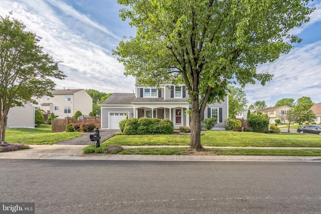 view of front of home featuring fence, aphalt driveway, a front lawn, and a garage