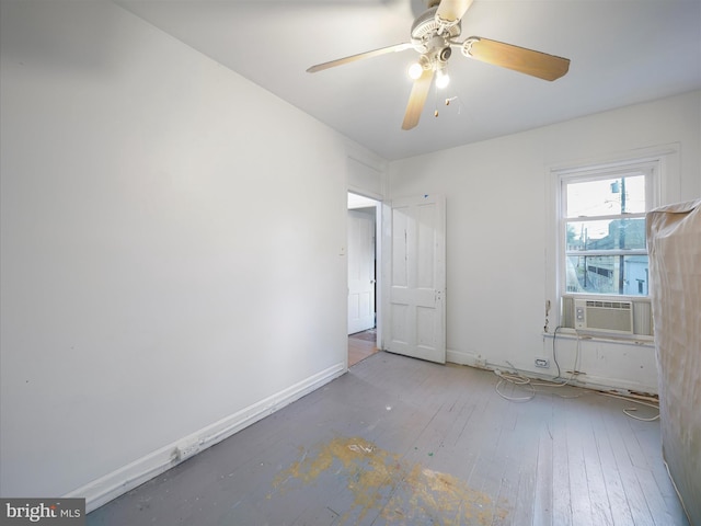 spare room with cooling unit, baseboards, a ceiling fan, and hardwood / wood-style floors
