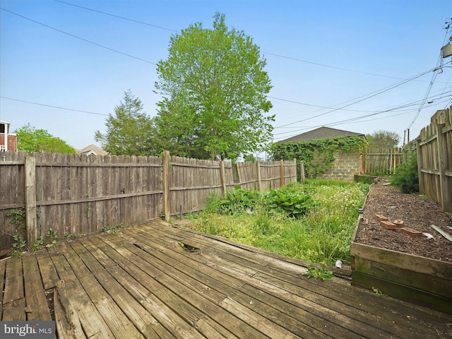 deck with a garden and a fenced backyard