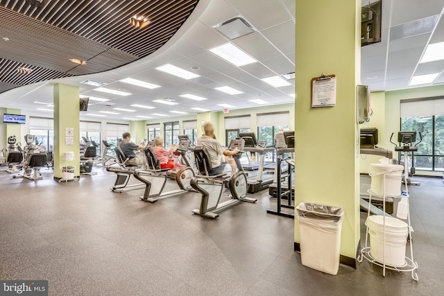 gym featuring a healthy amount of sunlight, a drop ceiling, and visible vents