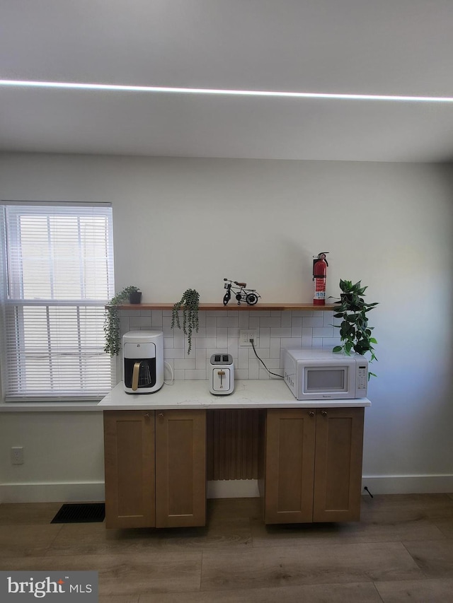 unfurnished office with baseboards and wood finished floors