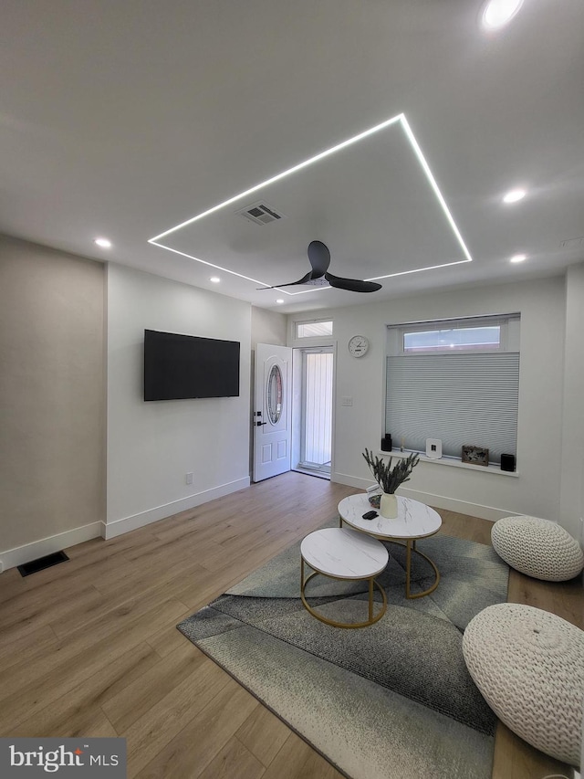 living room with a ceiling fan, visible vents, wood finished floors, and recessed lighting