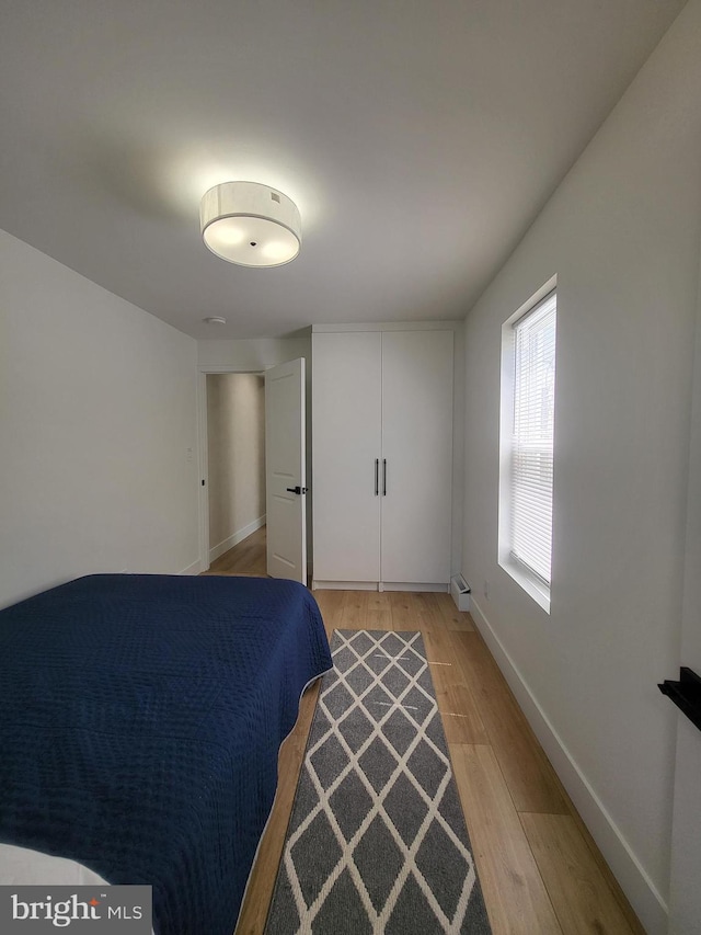 bedroom featuring light wood-style floors and baseboards