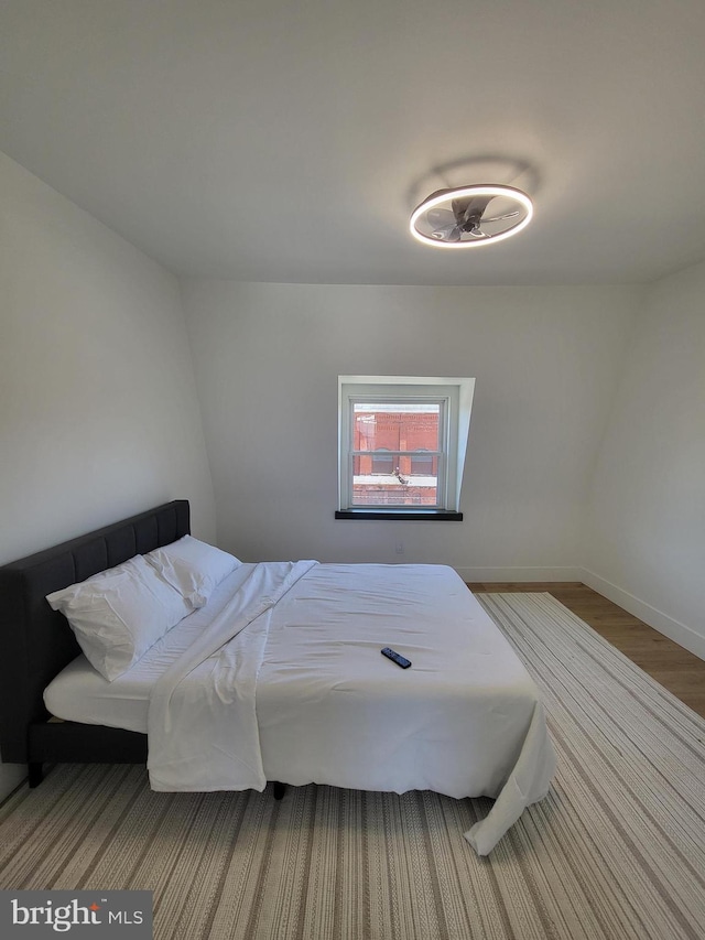 bedroom featuring baseboards and wood finished floors