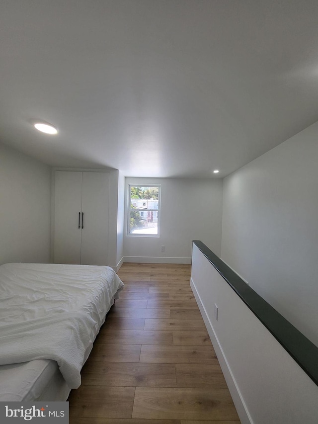 bedroom featuring recessed lighting, baseboards, and light wood-style flooring