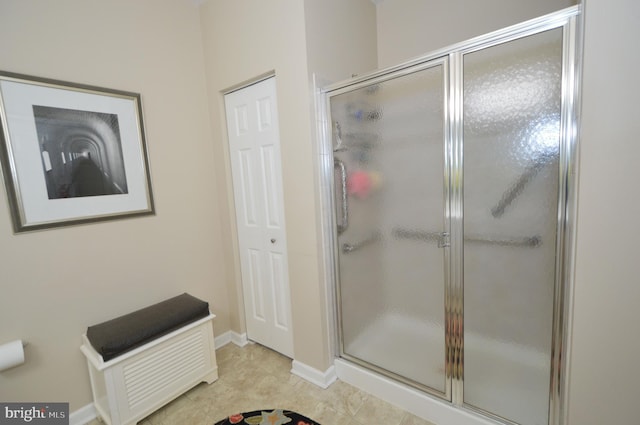 full bathroom featuring tile patterned floors, baseboards, and a shower stall