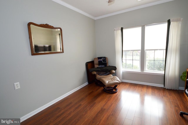 sitting room with ceiling fan, wood finished floors, baseboards, and ornamental molding