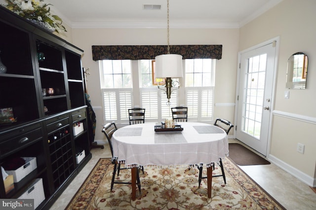 dining room with baseboards, ornamental molding, and visible vents