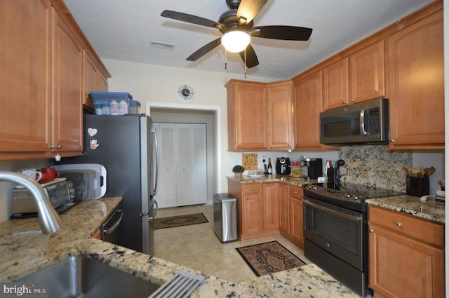 kitchen featuring stainless steel microwave, light stone counters, visible vents, black electric range, and a ceiling fan