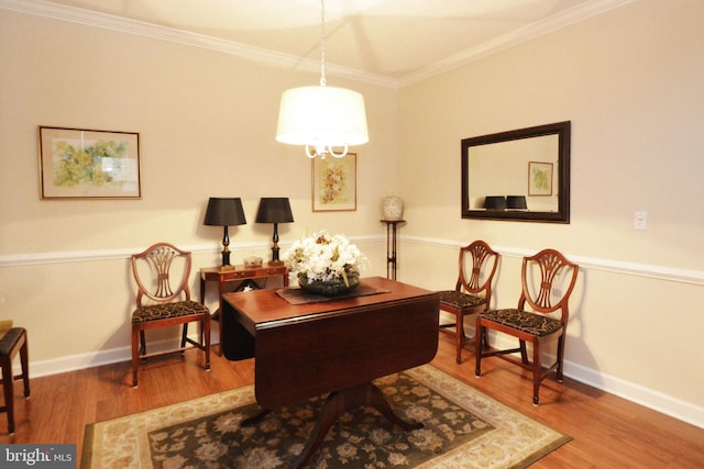 sitting room featuring baseboards, ornamental molding, and wood finished floors