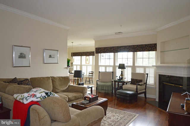 living area with crown molding, a glass covered fireplace, and wood finished floors