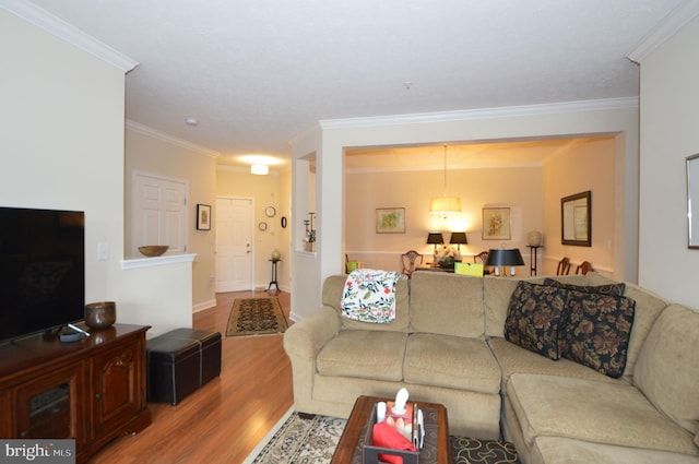 living room with ornamental molding, baseboards, and wood finished floors