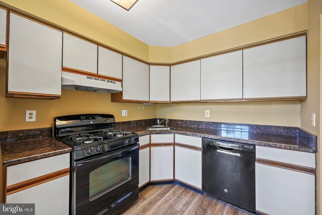 230 Mill Run Ct, Hightstown, NJ 08520 - kitchen with white cabinets, dark countertops, wood finished floors, under cabinet range hood, and black appliances