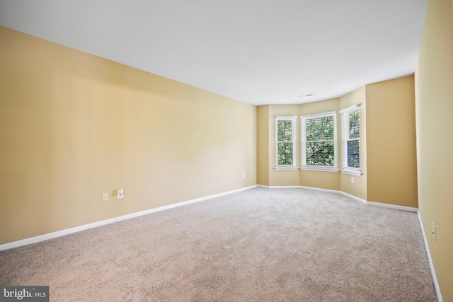 carpeted empty room featuring baseboards