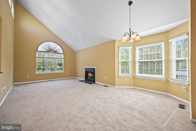 unfurnished living room with baseboards, a notable chandelier, carpet flooring, and visible vents