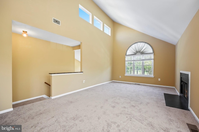 unfurnished living room featuring a fireplace with flush hearth, high vaulted ceiling, carpet flooring, and visible vents