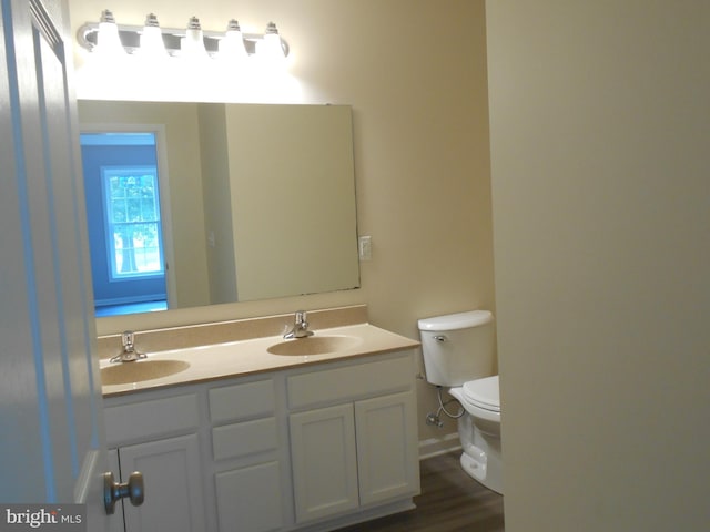 6271 Solomons Cir, Hurlock, MD 21643 - bathroom featuring toilet, double vanity, baseboards, and wood finished floors