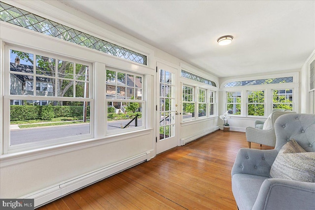 sunroom / solarium featuring baseboard heating and wood finished floors