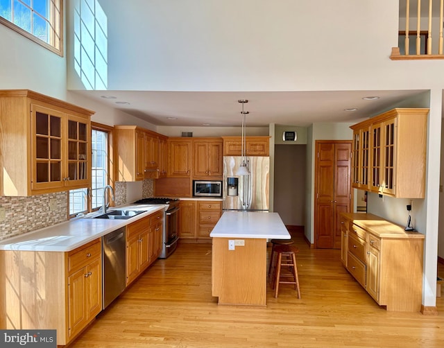 924 Hughes Dr, Hamilton, NJ 08690 - kitchen with appliances with stainless steel finishes, backsplash, a breakfast bar area, and a wealth of natural light