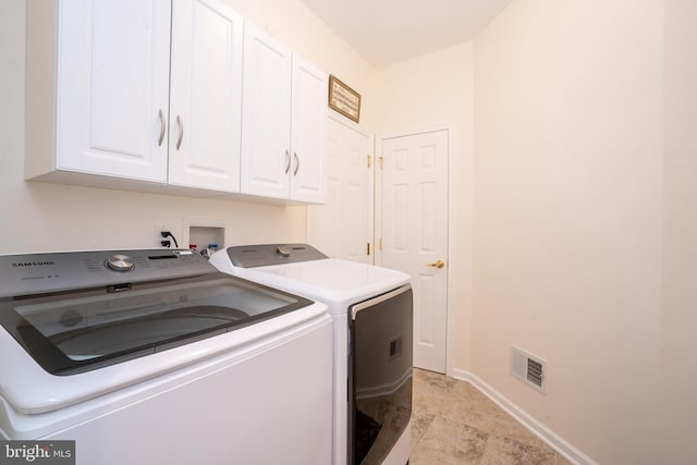 laundry room featuring cabinet space, baseboards, visible vents, and washer and clothes dryer